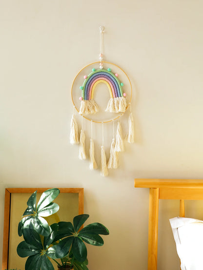 Decorative rainbow wall hanging with tassels on a light-colored wall. Handmade macrame rainbow wall hanging boho home decor