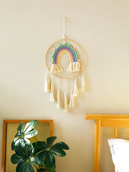 Decorative rainbow wall hanging with tassels on a light-colored wall. Handmade macrame rainbow wall hanging boho home decor