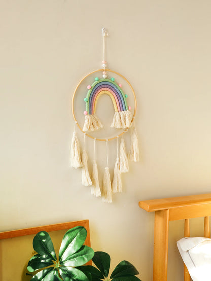 Decorative rainbow wall hanging with tassels on a light beige wall. Handmade macrame rainbow wall hanging boho home decor