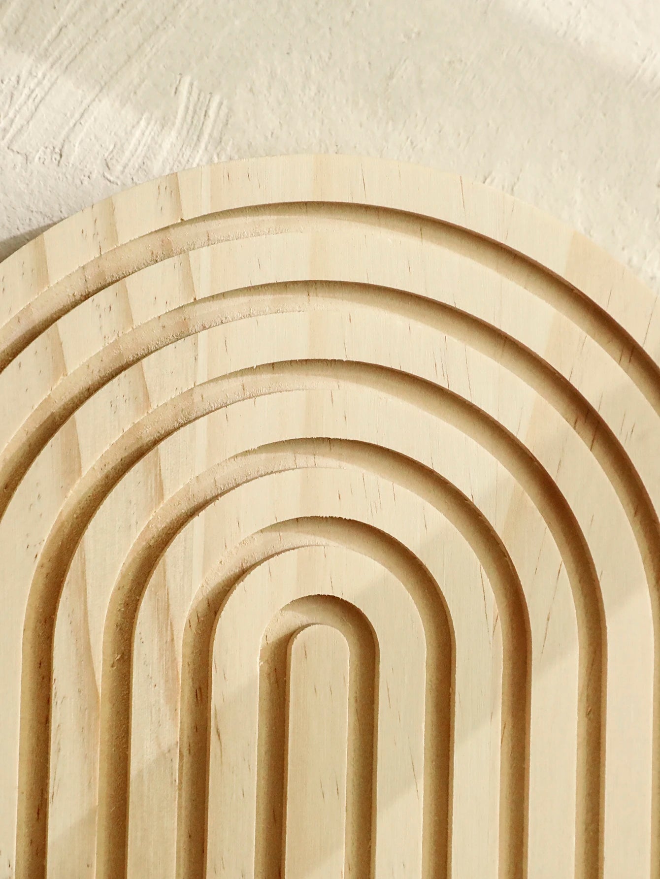 Wooden arches arranged in a circular pattern on a light background