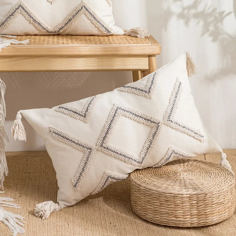 Decorative pillow with geometric pattern on a woven stool in a home setting Nordic blue tufted cushion cover with geometric stripe and grid crochet pattern, tassel pillow cover for sofa, bed, and boho home decor