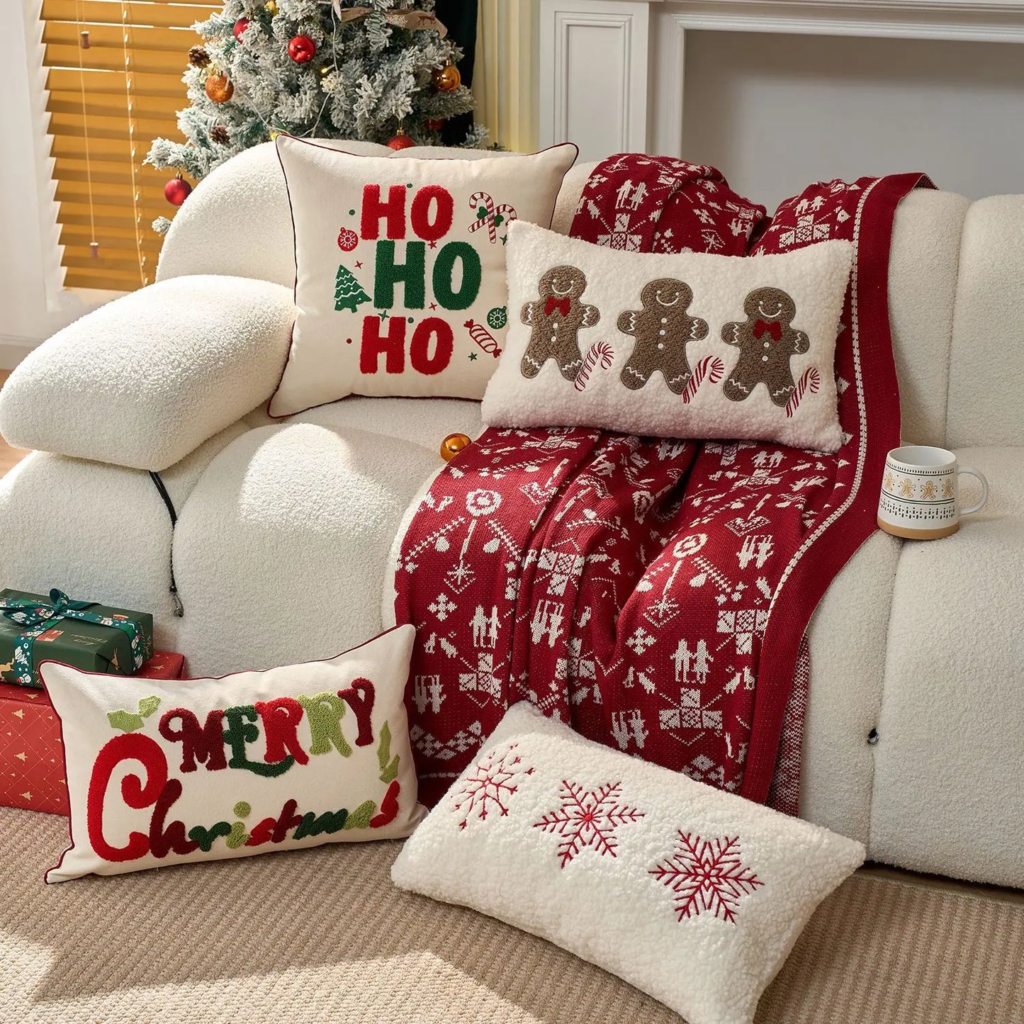 Decorative Christmas pillows with Ho Ho Ho, Gingerbread Men, Merry Christmas and snowflakes and blanket on a sofa with festive decor.