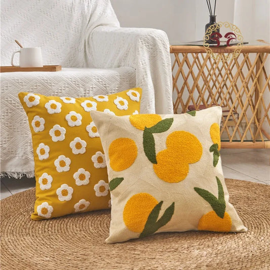 Two decorative pillows with floral and fruit patterns on a textured surface.