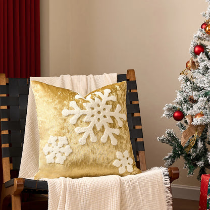 Gold pillow with snowflake patterns on a chair next to a decorated Christmas tree.Embroidered Merry Christmas pillow cover with snowflake design – festive red and white holiday cushion for sofa or bedroom décor.