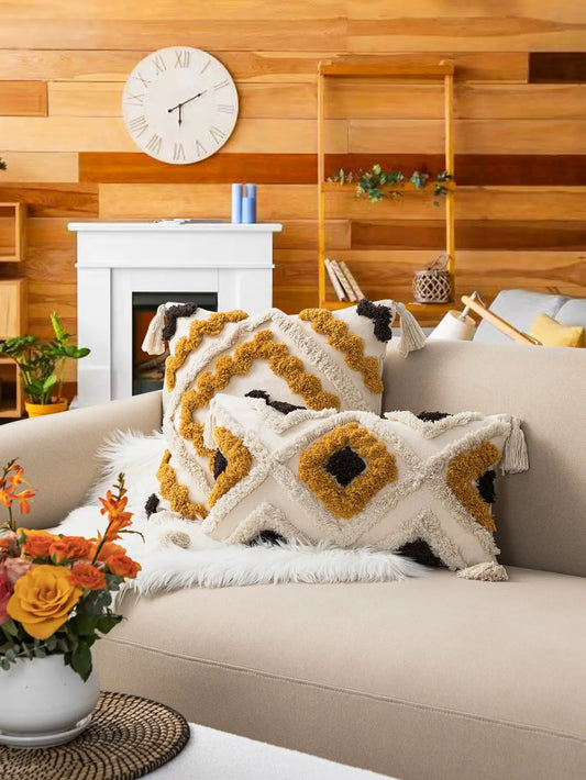 Decorative Bohemian pillows on a couch in a living room with wooden walls and a fireplace.