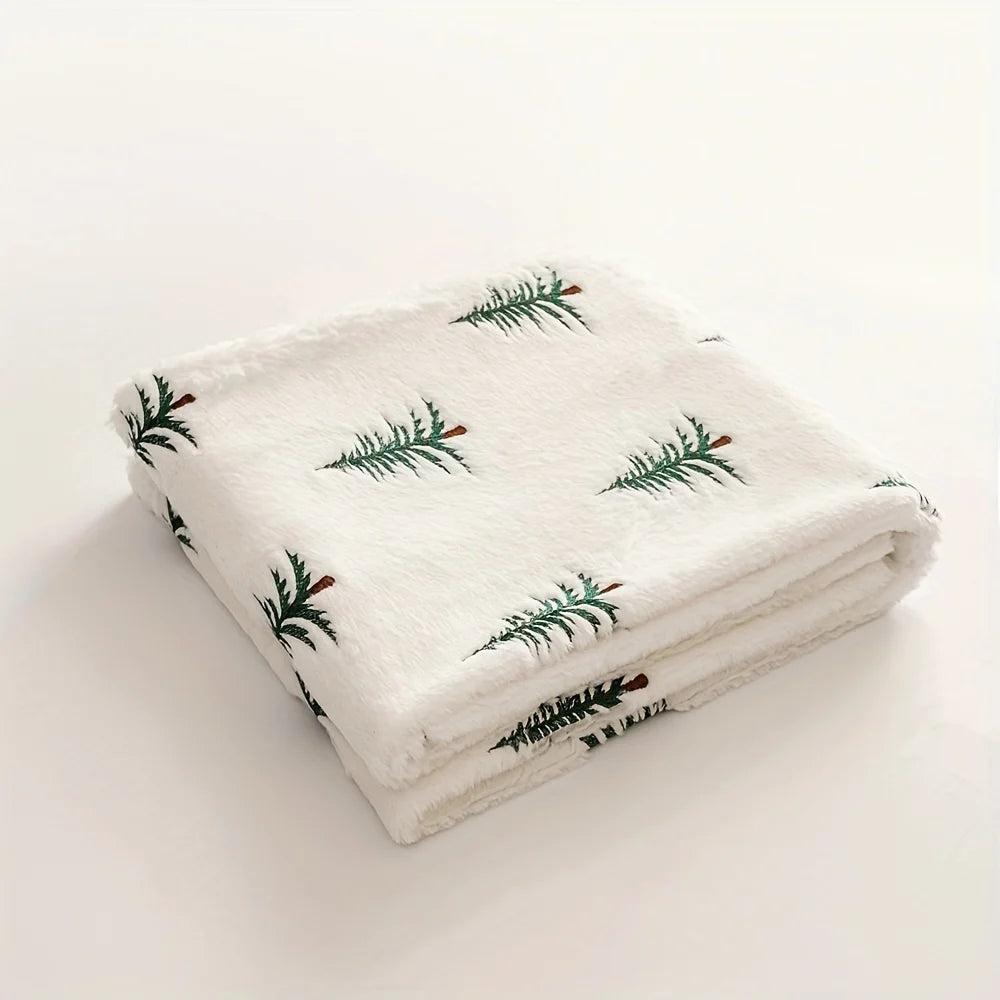 Folded blanket with green Christmas Tree  pattern on a white background