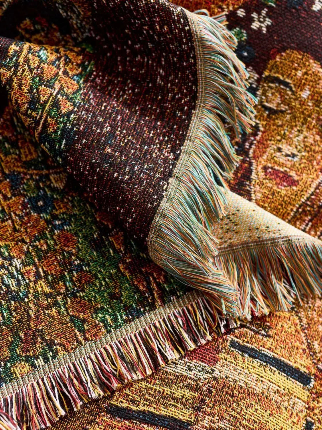 Close-up of a textured fabric with fringes on a patterned background. Cat woven throw blanket for boho sofa and home decor