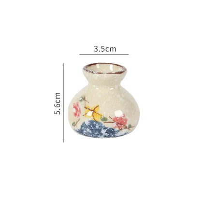 Small decorative vase with floral design and measurements on a white background