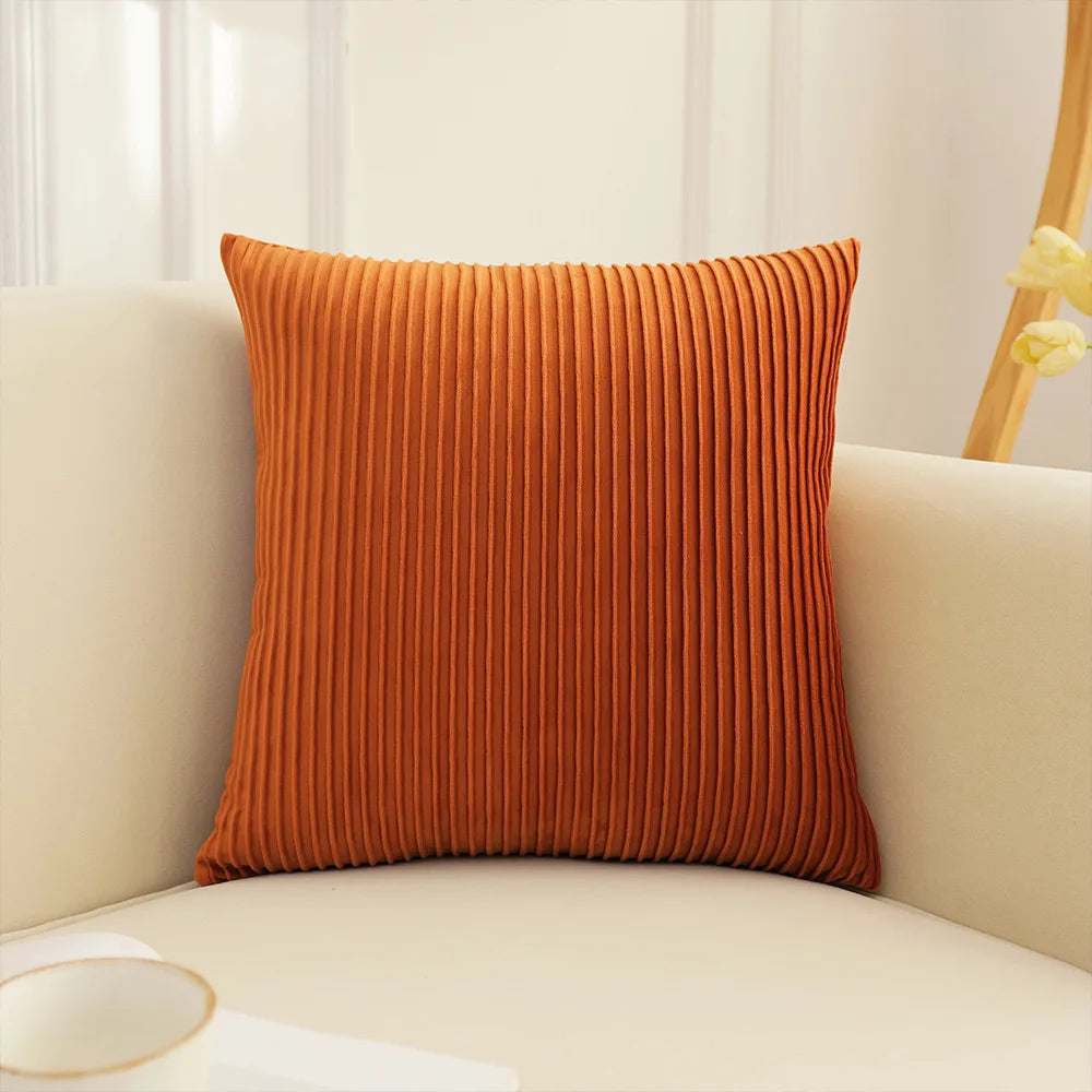 Orange textured pillow on a beige sofa with a blurred background. Handmade patchwork floral pillowcase for bed or living room