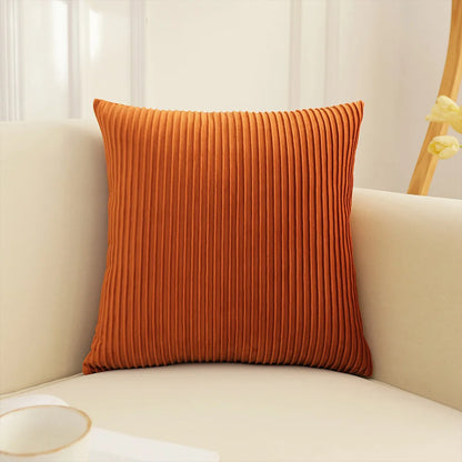 Orange textured pillow on a beige sofa with a blurred background. Handmade patchwork floral pillowcase for bed or living room