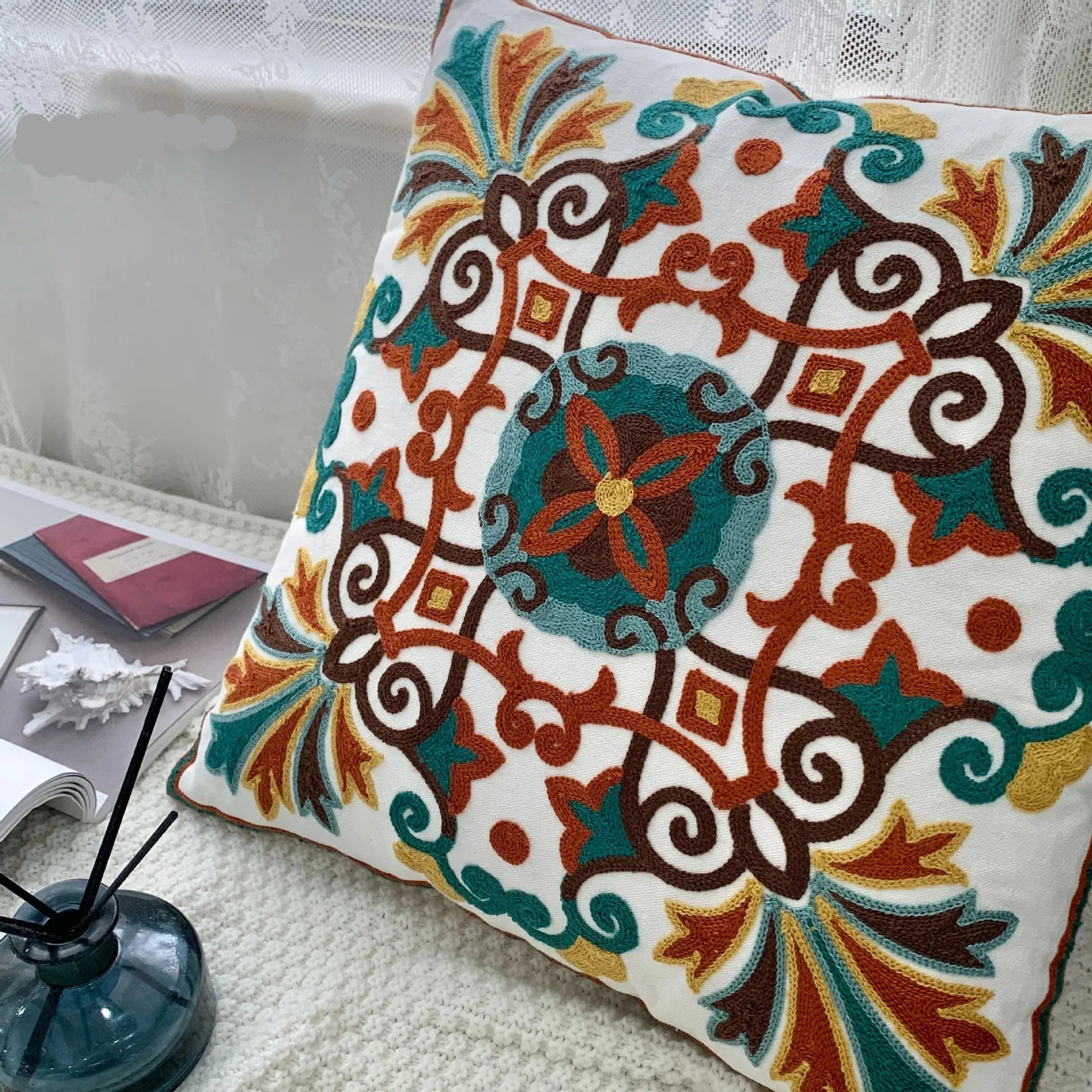 Decorative pillow with intricate patterns on a couch, floral embroidery on linen cotton cushion cover – boho home decor accent
