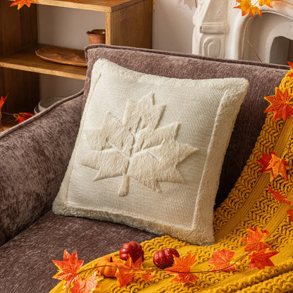 Decorative pillow with a leaf pattern on a couch surrounded by autumn leaves and decorations. Halloween pumpkin plush pillow cover for sofa and bed decor.
