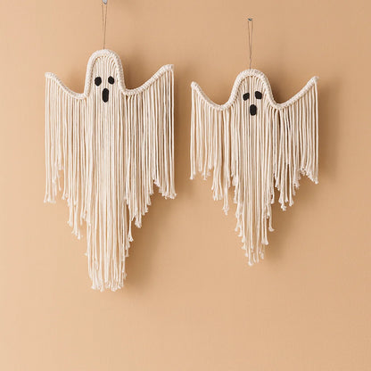 Two macrame ghost wall hangings in off-white cotton cord with black embroidered eyes and mouths, hanging against a warm beige background from My Boho Home