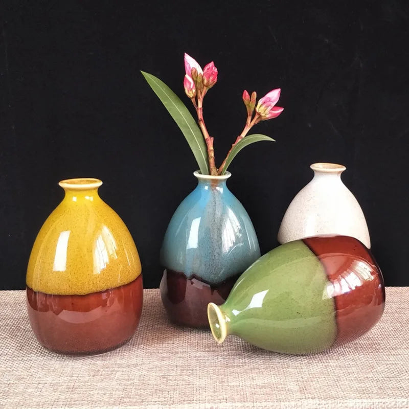 Set of colorful ceramic vases on a textured surface with a black background