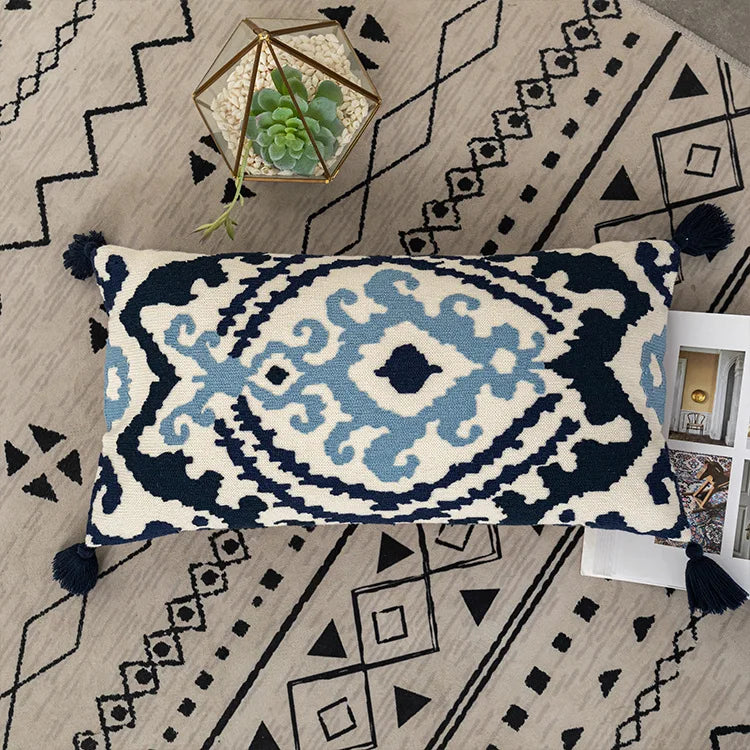 Decorative pillow with geometric pattern on a patterned rug. Bohemian embroidered throw pillow cover with geometric design, cotton-blend cushion for sofa, bed, or modern home decor.