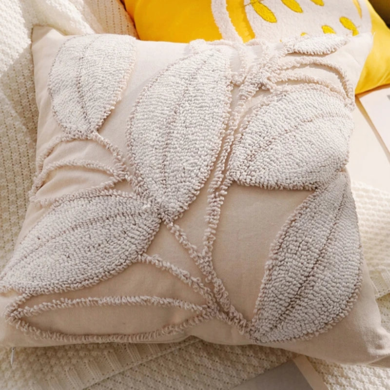 Close-up of a textured beige pillow with leaf patterns on a yellow background