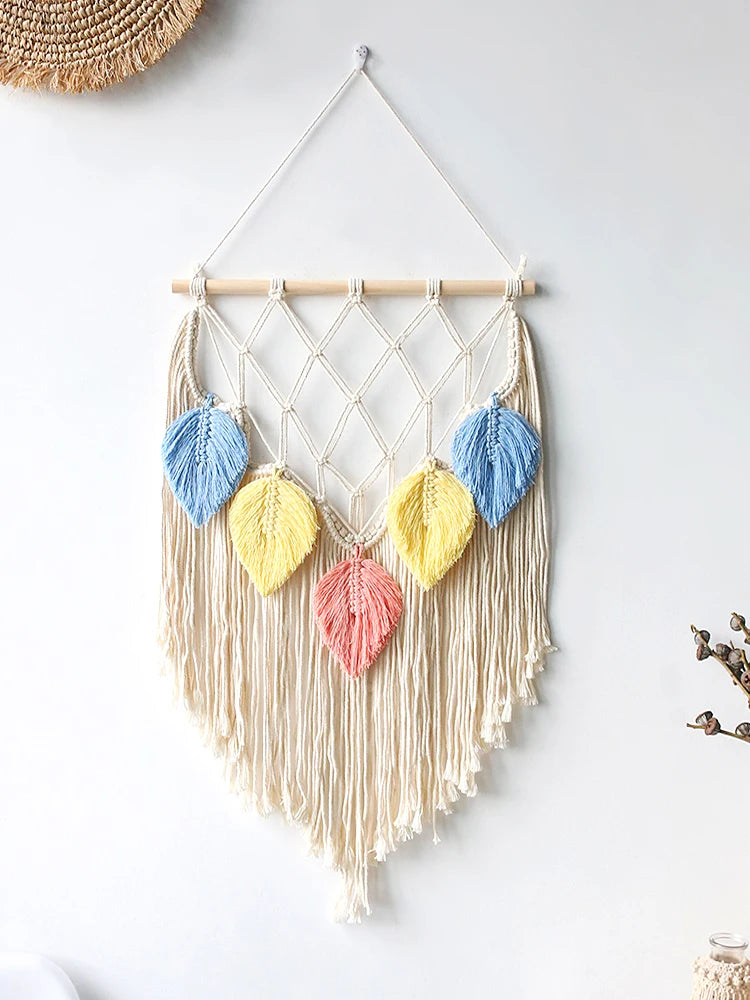 Macrame wall hanging with colorful leaf-shaped decorations on a white background. boho macrame