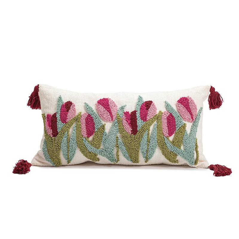Decorative pillow with embroidered tulips and tassels on a white background