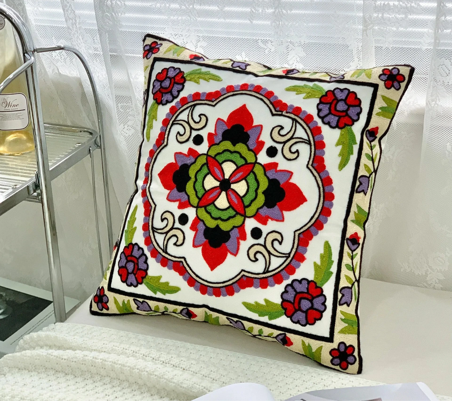 Decorative pillow with colorful floral pattern on a white surface, floral embroidery on linen cotton cushion cover – boho home decor accent