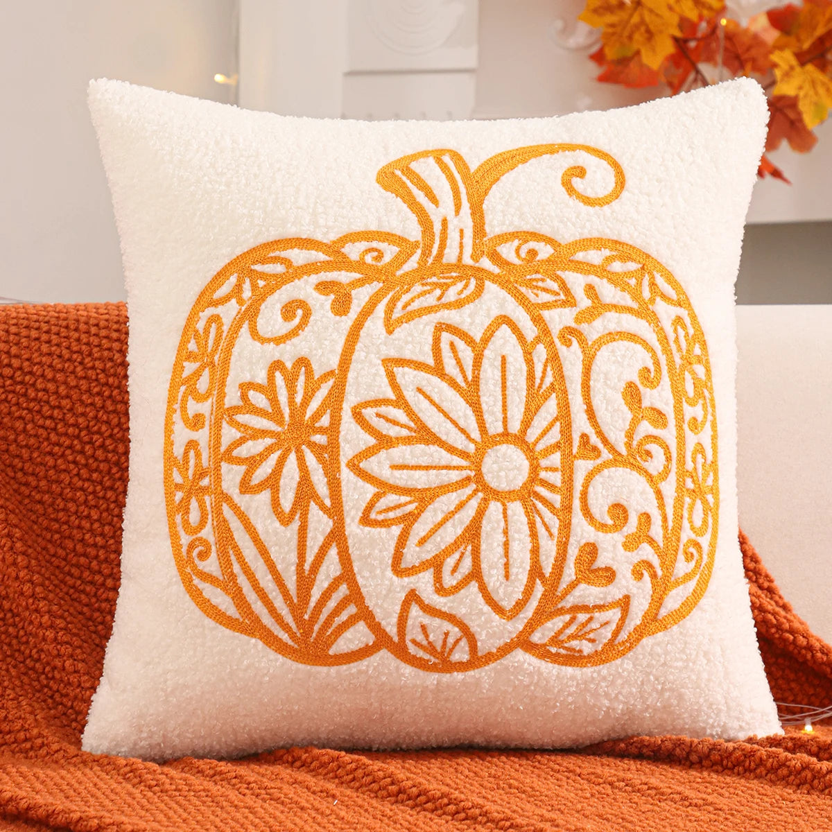 Decorative pillow with a pumpkin design on an orange couch.fall boho pillow throw gift ideas