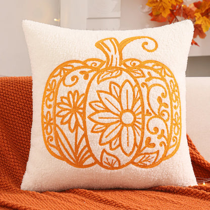 Decorative pillow with a pumpkin design on an orange couch.fall boho pillow throw gift ideas