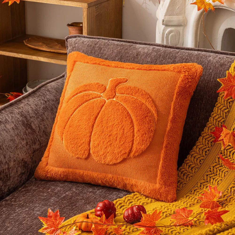 Orange pillow with pumpkin design on a brown couch with autumn decorations. Halloween pumpkin plush pillow cover for sofa and bed decor.