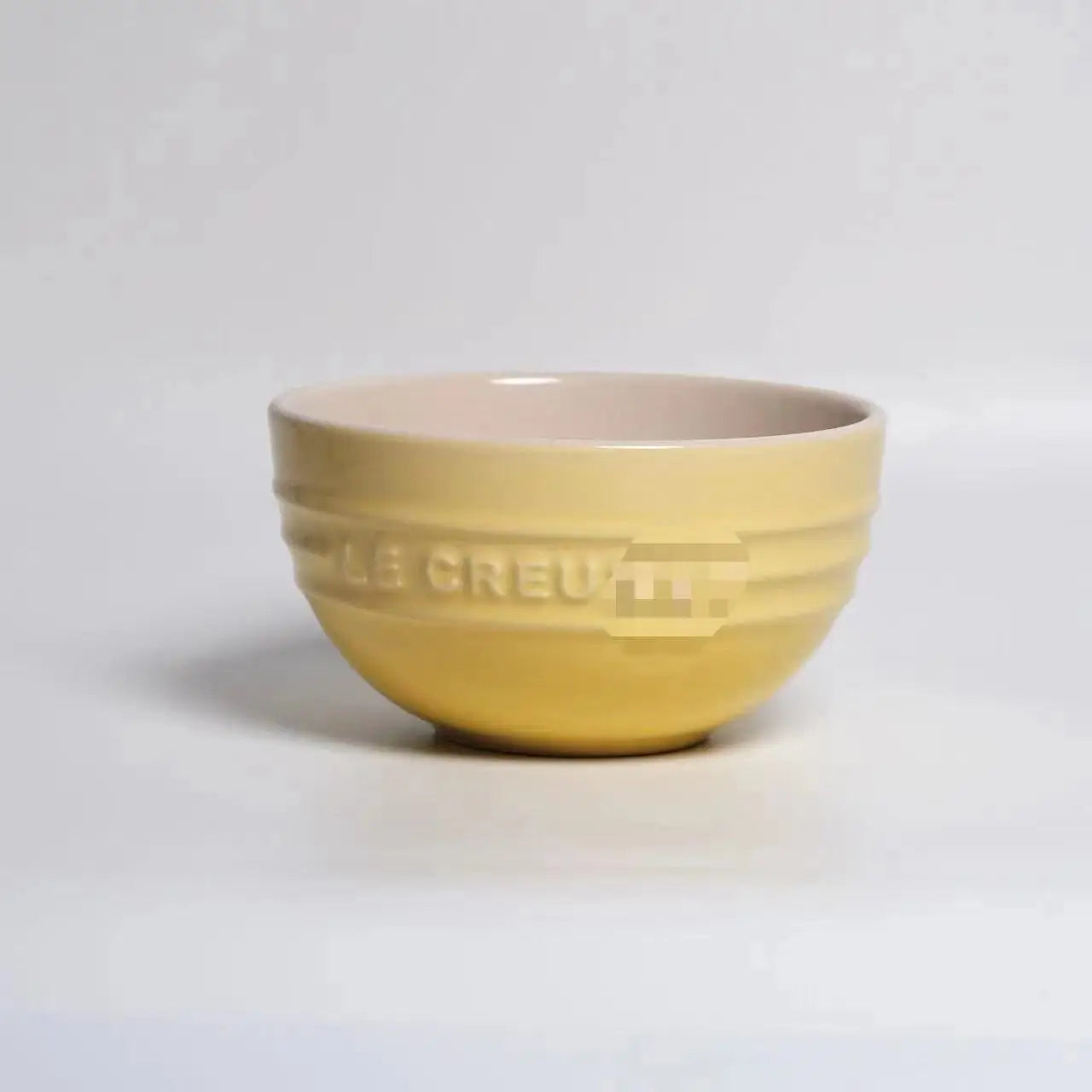 Yellow ceramic bowl with 'Le Creuset' branding on a light gray background Gradient ceramic rice bowl in bright colors, bone china soup and noodle bowl, dessert and pudding kitchen tableware for boho home dining