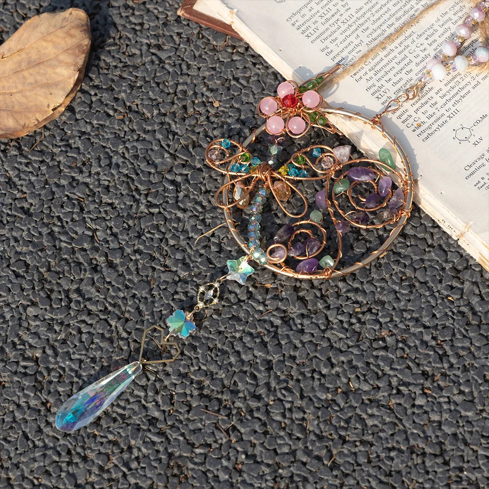 Decorative brooch with beads and a teardrop-shaped pendant on a textured surface. boho home decor, crystal wind chime, sun catcher for windows, moon prism chime, agate stone hanging, garden art decor, patio hanging decoration, boho housewarming gift, spiritual gift, crystal suncatcher, balcony decor, meditation decor, handmade crystal chime