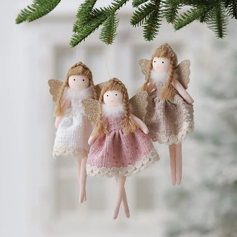 Three angel figurines with different dresses hanging against a blurred natural background