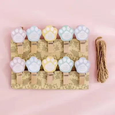 Set of 10 paw-shaped clips on a cardboard backing with a pink background