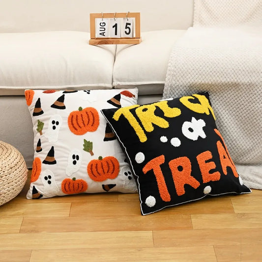 Two Halloween-themed pillows on a couch with a calendar showing August 15th.
