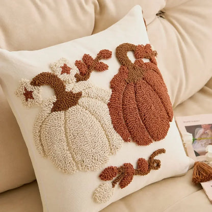 Decorative pillow with pumpkin and leaf patterns on a beige couch. Orange tufted pumpkin throw pillowcase for autumn boho home decor