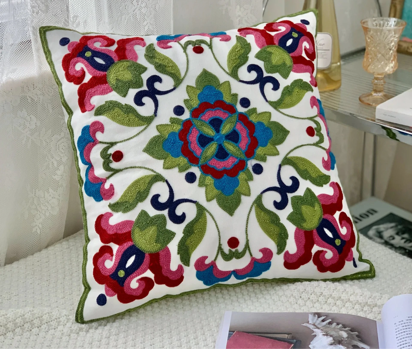 Decorative pillow with colorful floral pattern on a white background Handcrafted embroidered cushion cover on armchair – modern boho living room decor