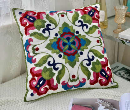 Decorative pillow with colorful floral pattern on a white background Handcrafted embroidered cushion cover on armchair – modern boho living room decor