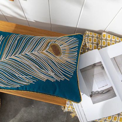 Decorative pillow with peacock feather design on a wooden surface. Bohemian embroidered throw pillow cover with geometric design, cotton-blend cushion for sofa, bed, or modern home decor.