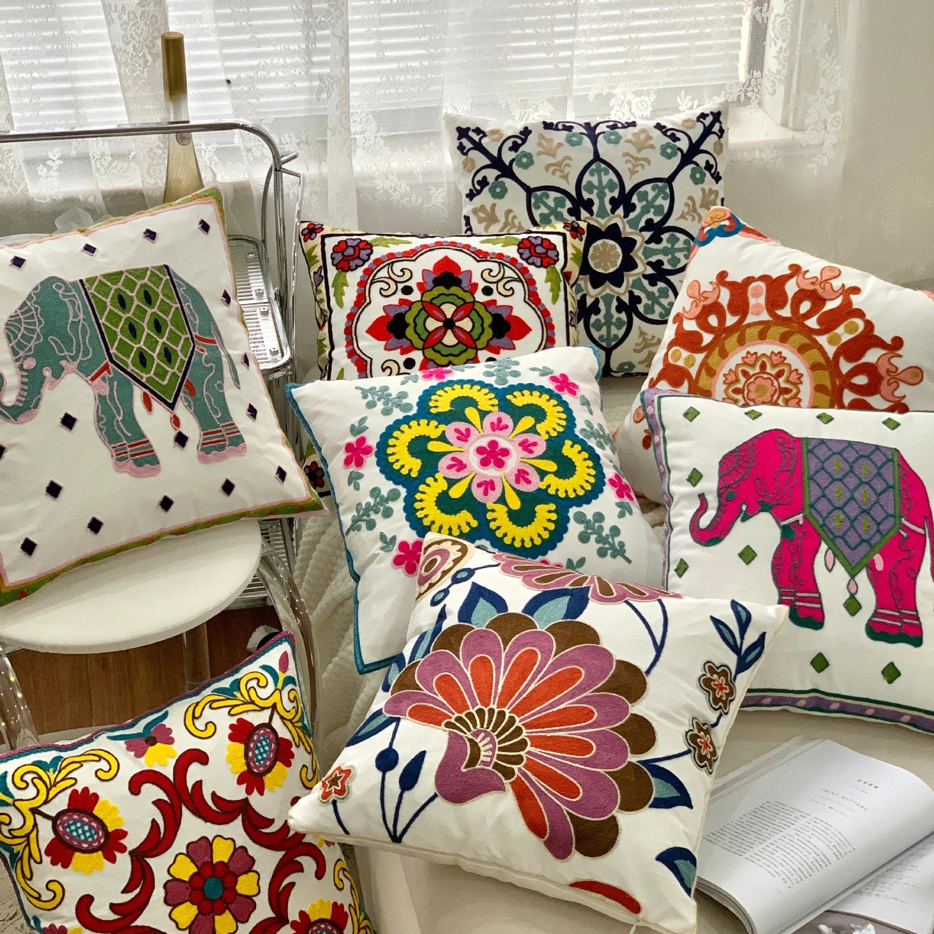 Colorful decorative pillows with various patterns on a chair. Handcrafted embroidered cushion cover on armchair – modern boho living room decor