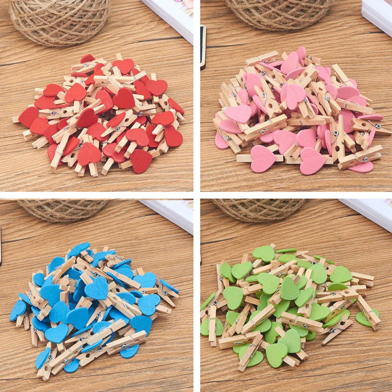 Four different colored heart-shaped wooden clips on a wooden surface.