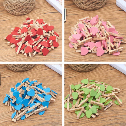 Four different colored heart-shaped wooden clips on a wooden surface.