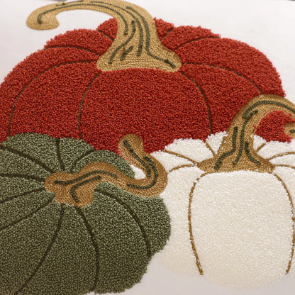 Decorative rug with red, green, and white pumpkins on a white background. Velvet pillow cover with embroidered pumpkins, sunflowers, and autumn leaves – cozy fall home décor for sofa or living room.