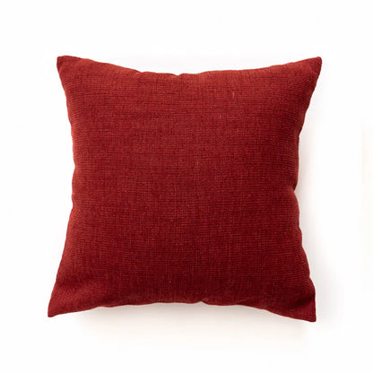Red pillow on a white background. Bohemian Aztec woven pillow cover, geometric jacquard cushion for sofa, bed, or living room decor in neutral cotton blend fabric.