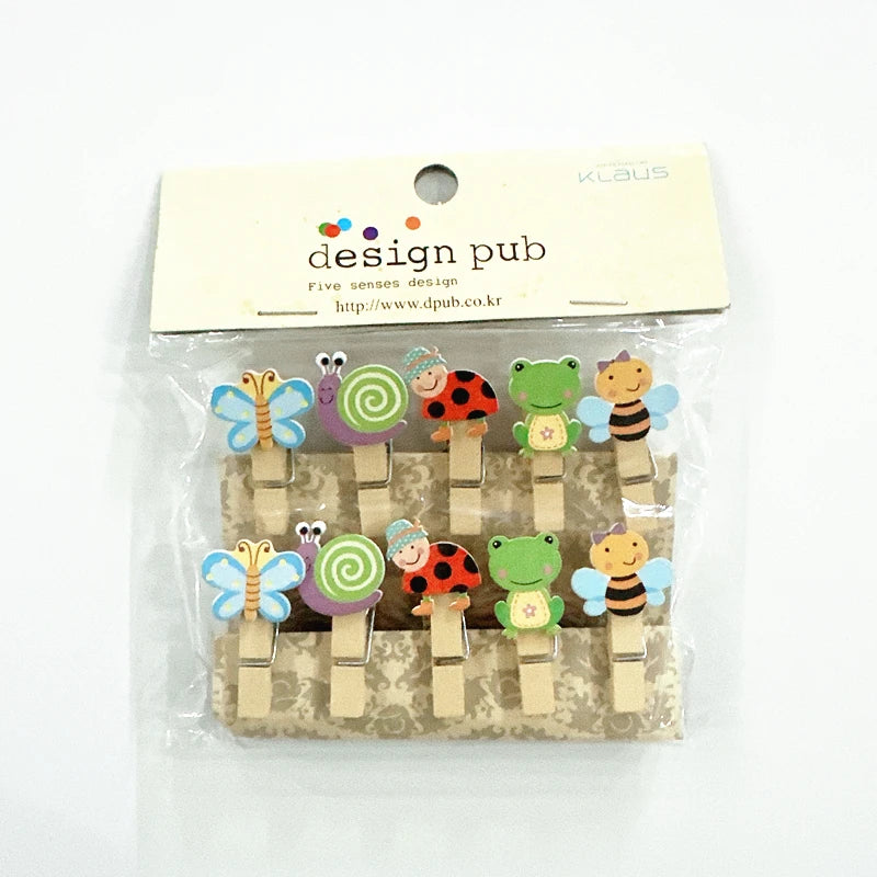 Set of colorful wooden clips with animal designs in packaging, branded 'design pub'.