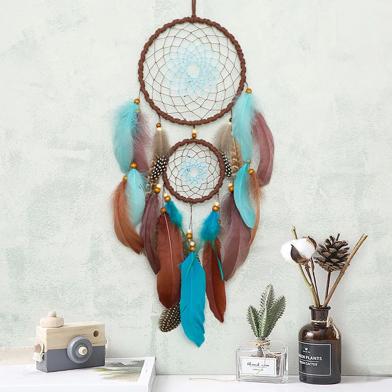 Dreamcatcher with feathers on a light gray wall with decor items below. boho home decor, housewarming gift, dream catcher wall hanging, feather wind chime, handmade dreamcatcher, colorful boho wall decor, birthday gift decor, modern bohemian style, bedroom hanging ornament, spiritual home decor, dreamcatcher nursery decor