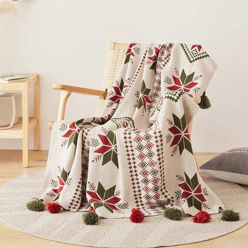 Decorative blanket with geometric snowflake patterns draped over a chair in a room.