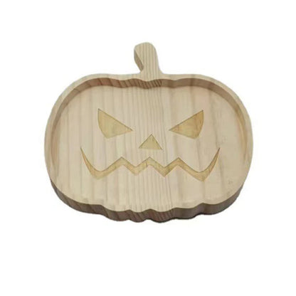Wooden pumpkin-shaped cutting board with a carved face on a white background. Wooden Halloween serving tray in pumpkin and ghost shapes, rustic snack and dessert plate for party décor and fall entertaining