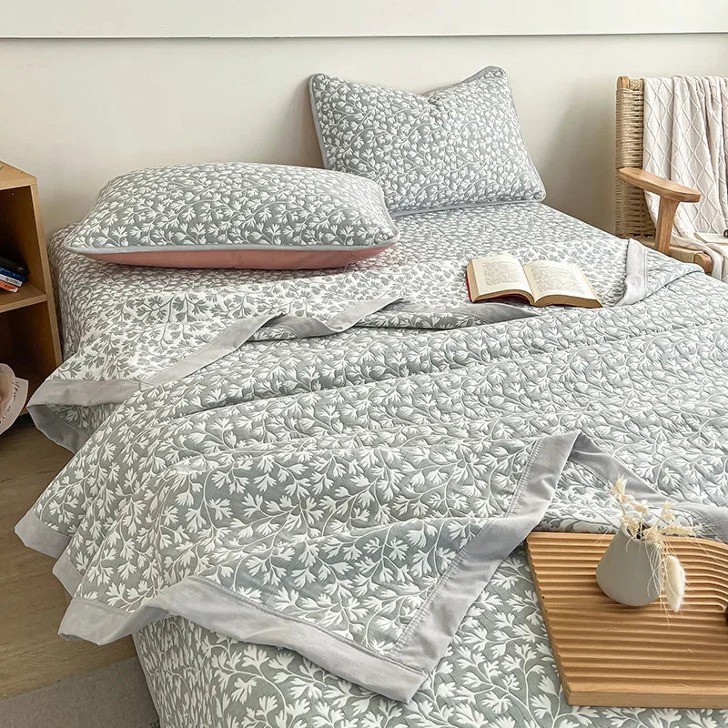 Bed with floral bedding and pillows in a bedroom setting. Boho breathable lightweight summer spring fall blanket quilt bedspread 