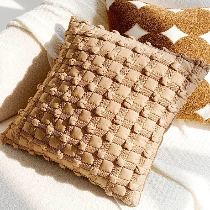 Textured brown pillow on a soft white surface