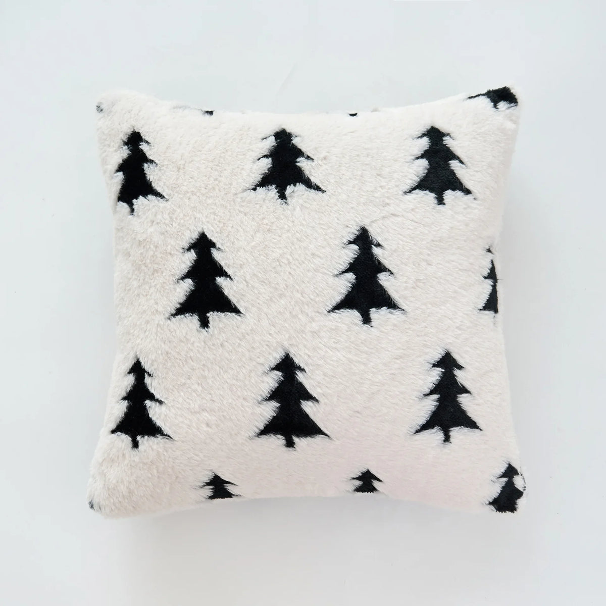 White pillow with black tree pattern on a light gray background