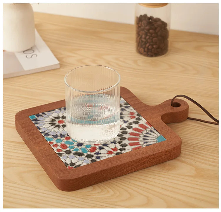 Wooden tray with geometric patterned coaster holding a glass of water on a wooden surface.