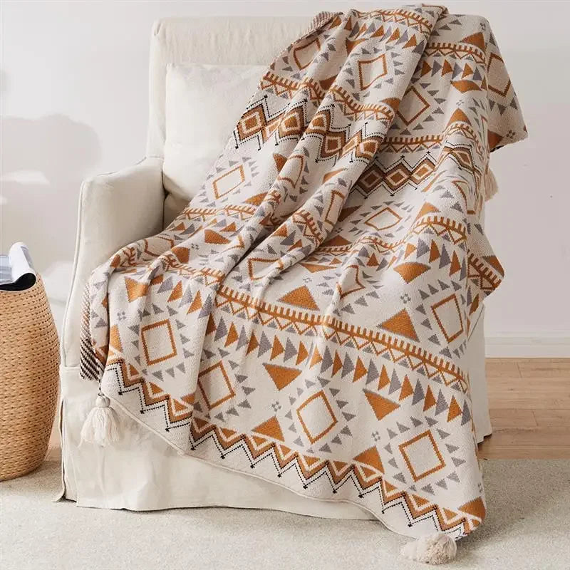 Patterned Bohemian blanket draped over a chair in a room with a neutral color scheme.