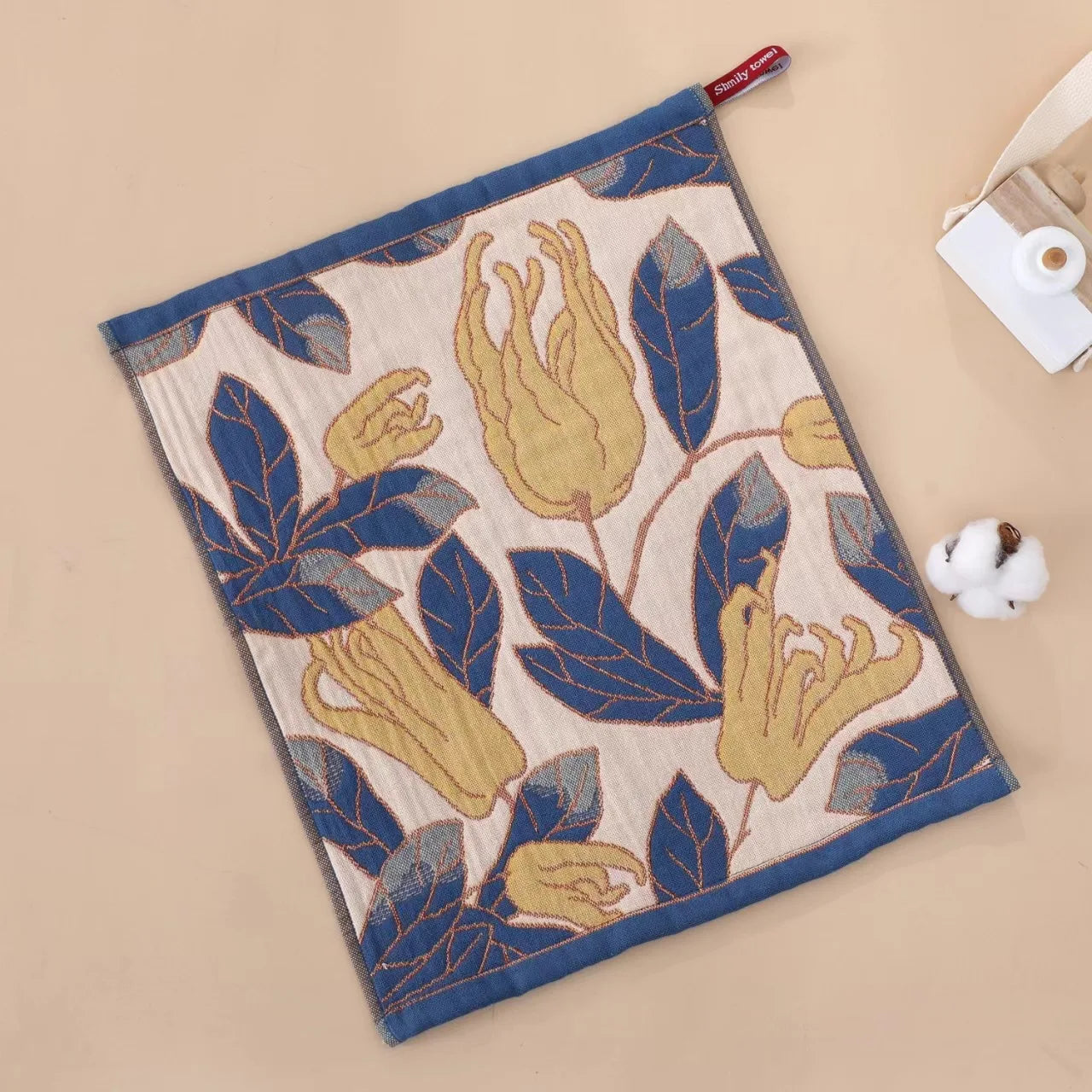 Decorative tea towel with floral pattern on a beige background